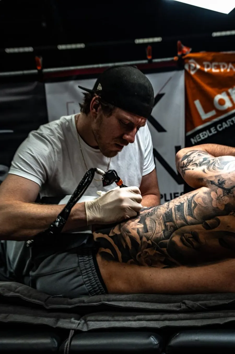 Isaac zet een tattoo op een conventie